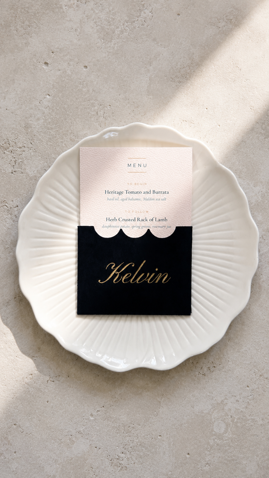 Gilded velvet place card with printed menu insert, flat lay on a pale surface