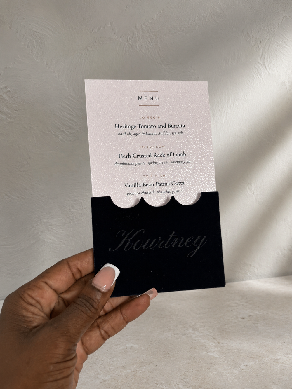 Navy velvet place card and printed menu insert styled on a cream plate
