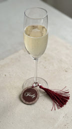 personalised wine glass charm place card with guest name in gold on champagne flute at wedding table