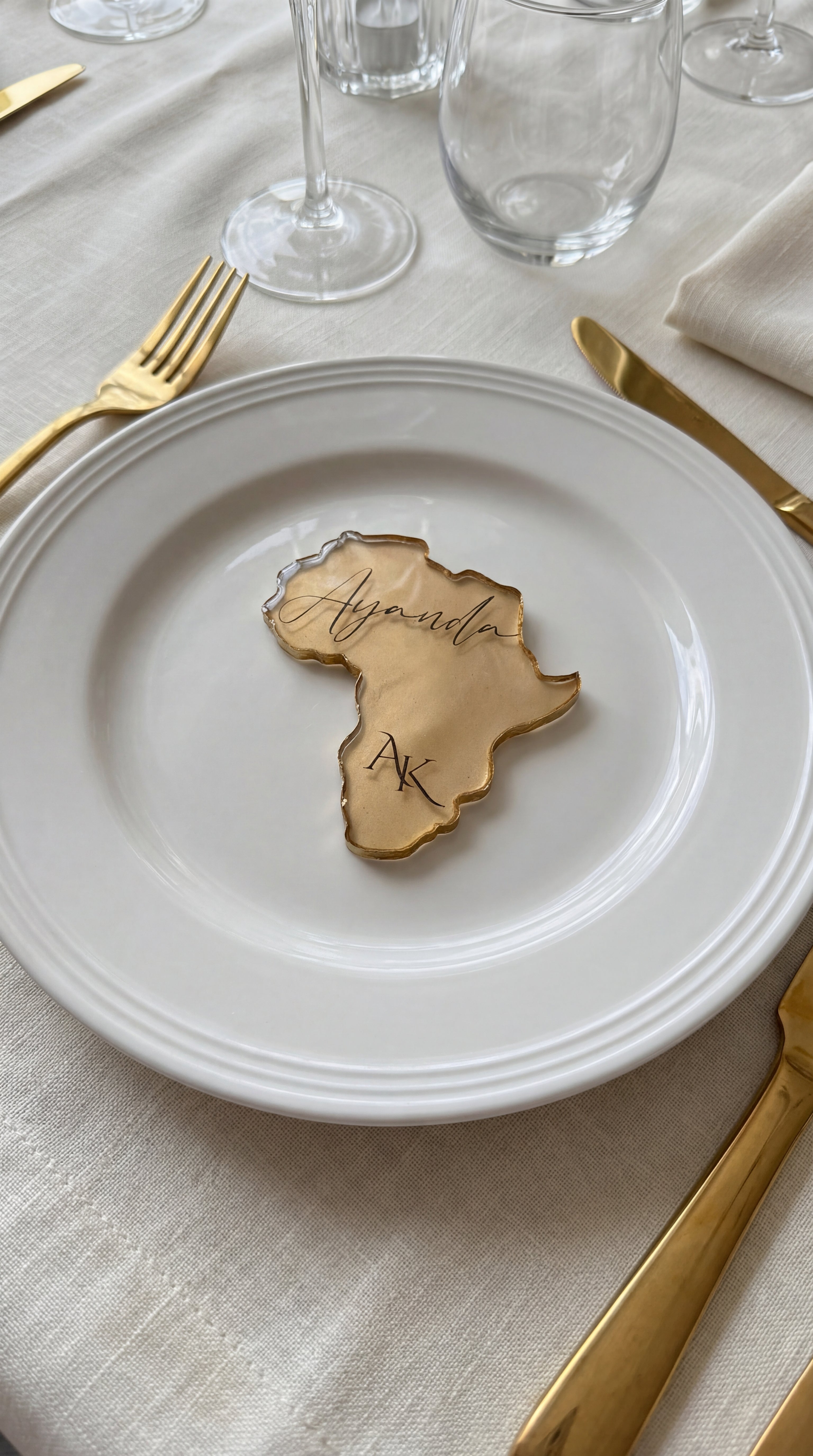 Africa silhouette resin place card with gold leaf held in hand showing size and transparency