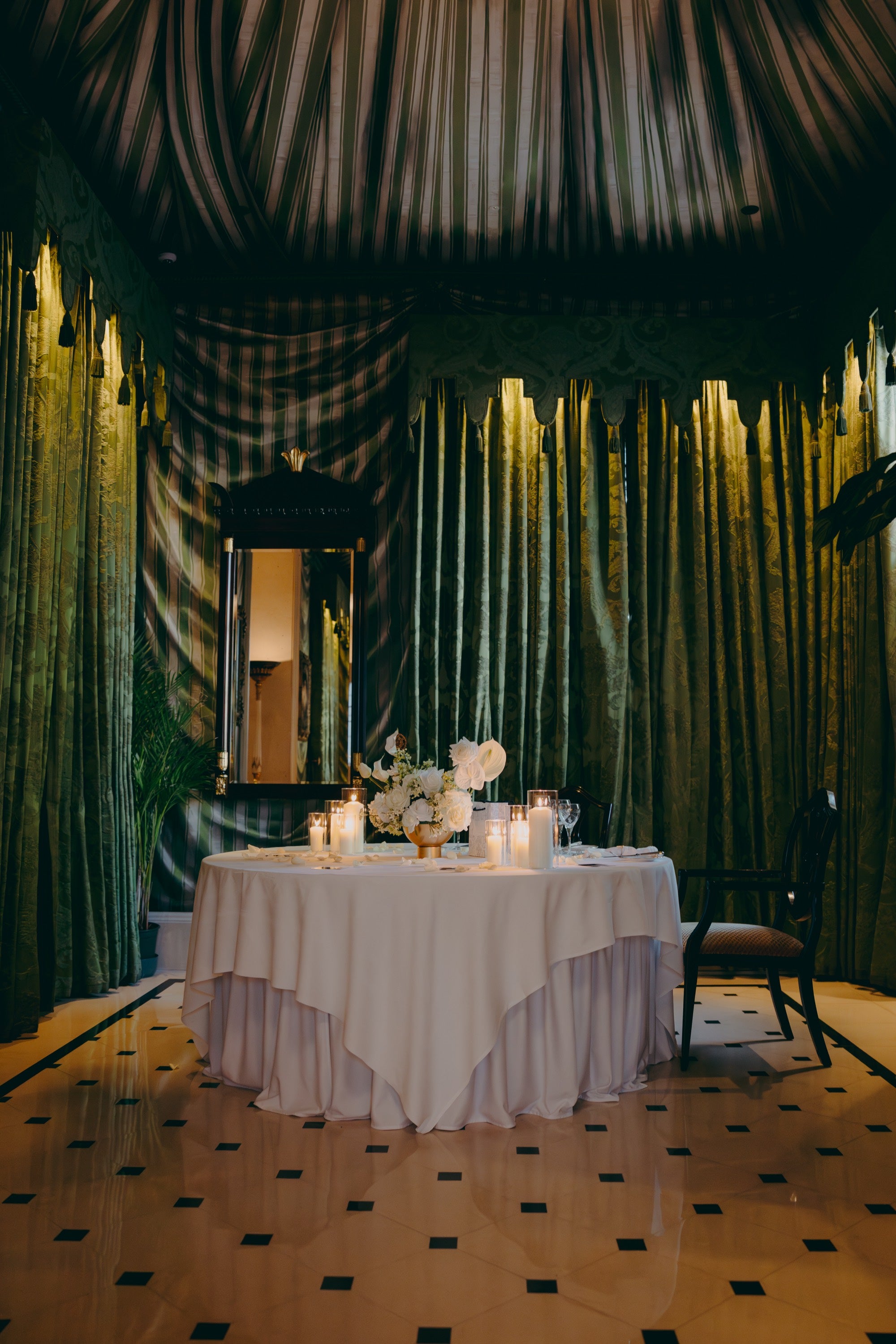 A private dining room at The Lanesborough dressed for a proposal, the table laid with candles and white florals